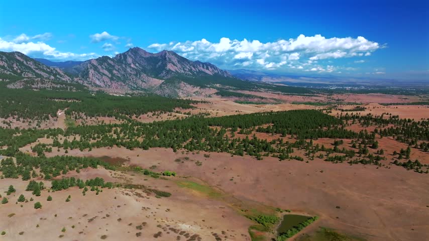 Aerial drone view City of Boulder vista The Flatirons South Boulder Colorado cityscape nature landscape summer fall autumn morning sunny blue sky Front Range Rocky Mountains Foothills pan right