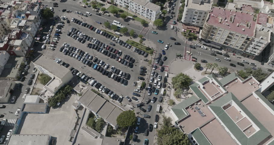 A rotating overhead view shows rows of parked cars surrounded by streets, buildings and trees in Tangier, Morocco.