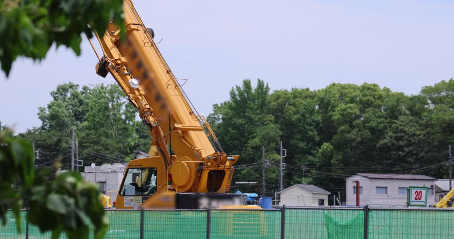 Moving tall cranes at the under construction in the public park cloudy day. High quality 4k footage. Nerima district Tokyo Japan 06.05.2023 Here is a downtown in Tokyo. 