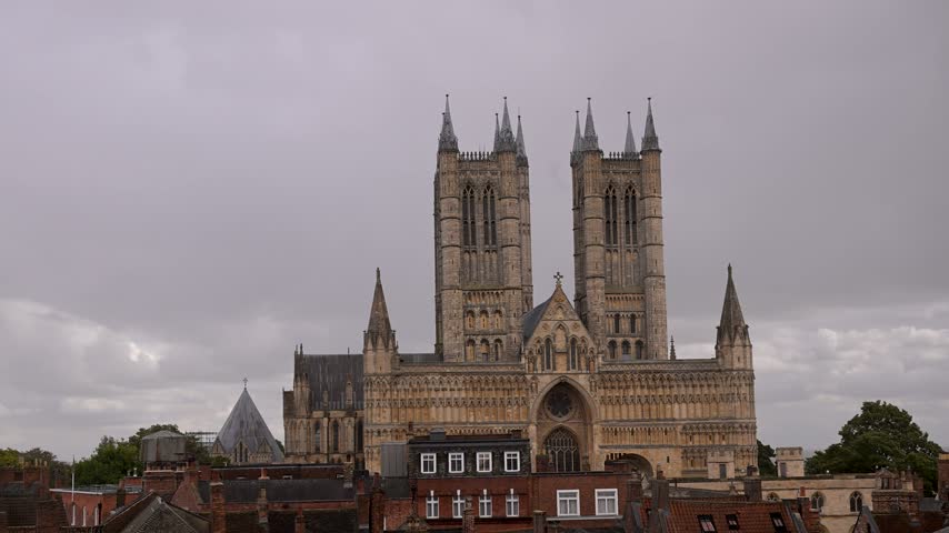 Lincoln Cathedral towers over surrounding rooftops under an overcast sky in a static daylight shot.