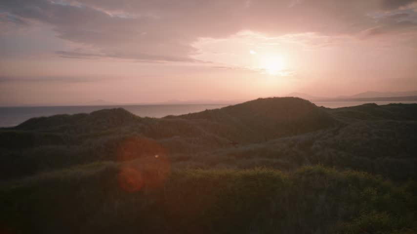 Sunset Over Coastal Dunes With Ocean Horizon At Dusk