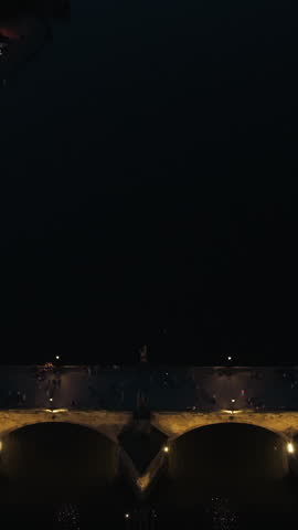 Illuminated Charles Bridge Spans The Vltava River At Night In Prague, Czech Republic. Vertical, Aerial Pullback Shot