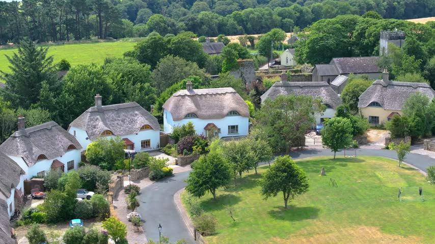 Traditional thatched cottages and modern homes encircle a leafy central green at St James Wood estate as the camera glides overhead.