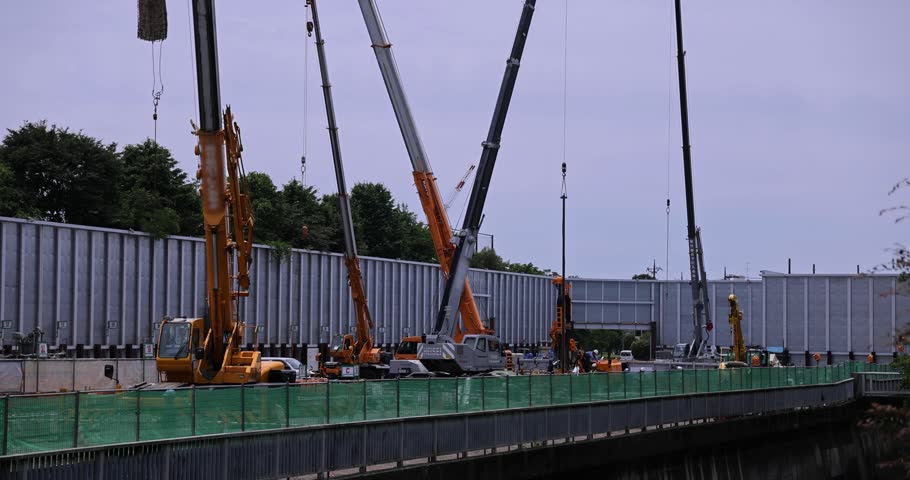 Moving tall cranes at the under construction in the public park cloudy day. High quality 4k footage. Nerima district Tokyo Japan 06.05.2023 Here is a downtown in Tokyo. 