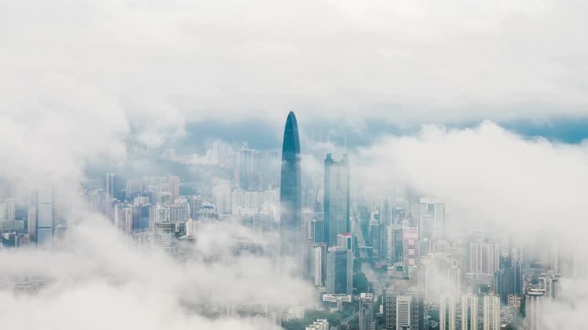 Aerial View of City Skyscrapers Piercing Through Clouds and Fog