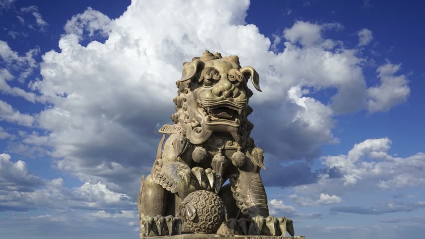 Bronze Guardian Lion Statue in Yonghe Temple (against the sky with clouds), also known as the Palace of Peace and Harmony Lama Temple, the Yonghe Lamasery, or popularly the Lama Temple, is a temple of Tibetan Buddhism. Beijing, China. 4K, time lapse 