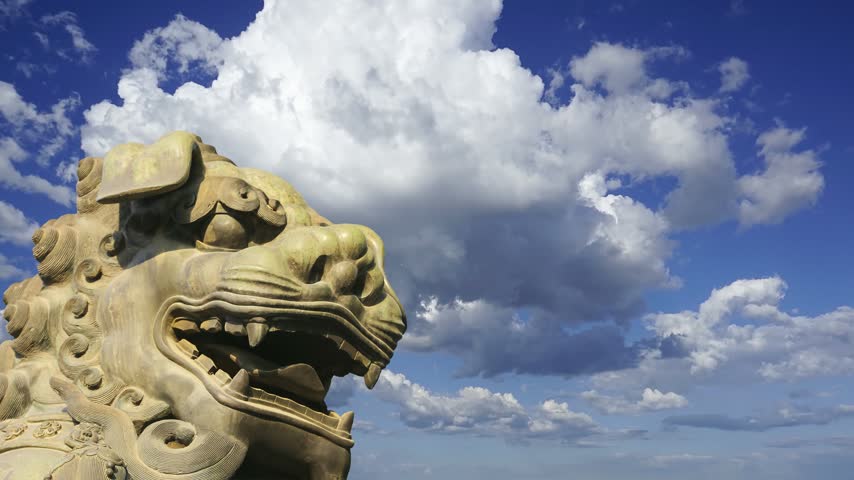 Bronze Guardian Lion Statue in Yonghe Temple (against the sky with clouds), also known as the Palace of Peace and Harmony Lama Temple, the Yonghe Lamasery, or popularly the Lama Temple, is a temple of Tibetan Buddhism. Beijing, China. 4K, time lapse 