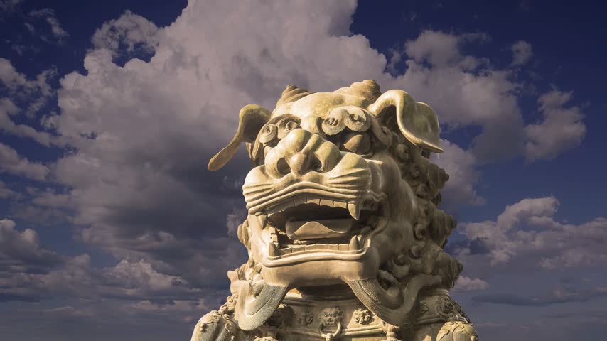 Bronze Guardian Lion Statue in Yonghe Temple (against the sky with clouds), also known as the Palace of Peace and Harmony Lama Temple, the Yonghe Lamasery, or popularly the Lama Temple, is a temple of Tibetan Buddhism. Beijing, China. 4K, time lapse 