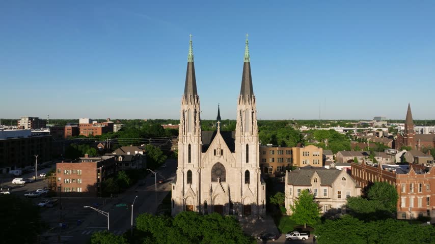 Aerial view of Saint Mary Catholic Church with its twin spires and stone facade surrounded by urban buildings in Indianapolis, Indiana, United States.