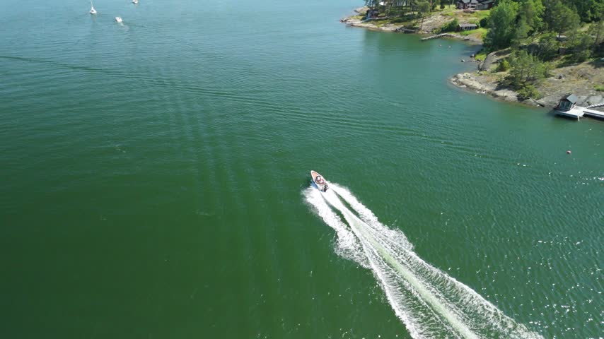Aerial footage captures a speedboat racing across Stockholm water with a long white wake
