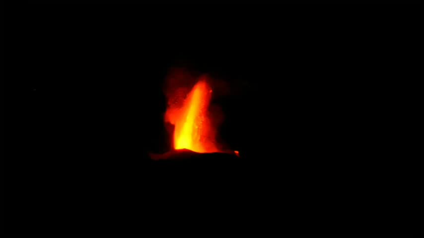 Spectacular volcanic eruption with glowing red lava fountain exploding against dark night sky.