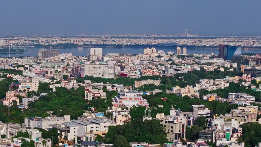 Density urban with hussain sagar lake, skylines and telangana Secretariat at hyderabad, india. day time, pan shot, drone shot, 4k.