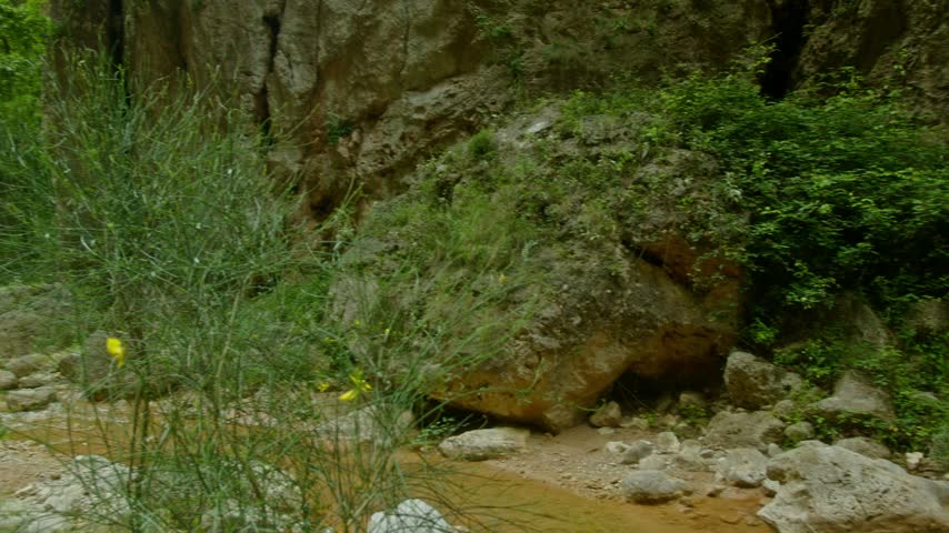 Albania, Vlore 2023 05 27: A wide angle landscape view of the Canyon of Gjipe showing towering rocky cliffs, lush green foliage, and natural terrain.