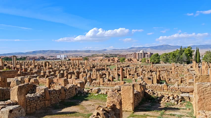 Ancient Roman ruins of Timgad with the Arch of Trajan under a clear blue sky in Algeria