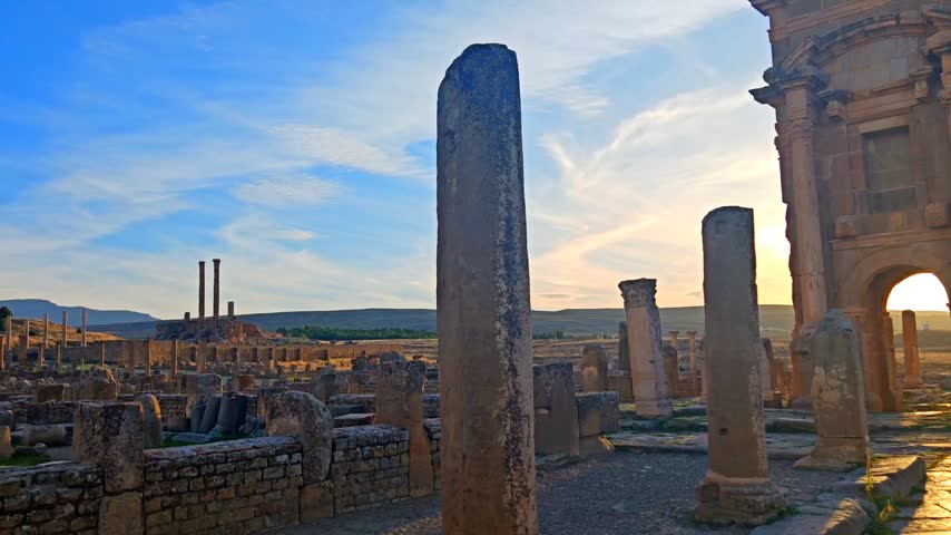 Ancient Roman ruins of Timgad with the Arch of Trajan under a clear blue sky in Algeria