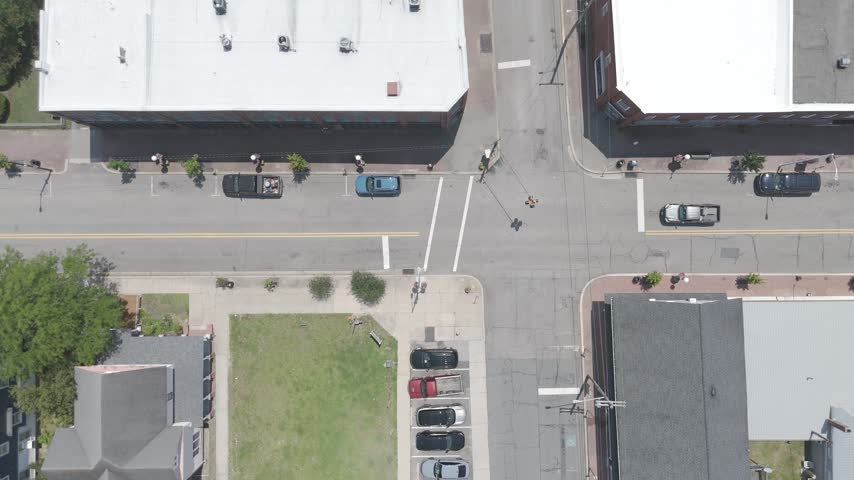 Top down aerial view looking straight down on the main street of a small American town with storefront rooftops, parked cars and crosswalks, Denton, Maryland, USA.