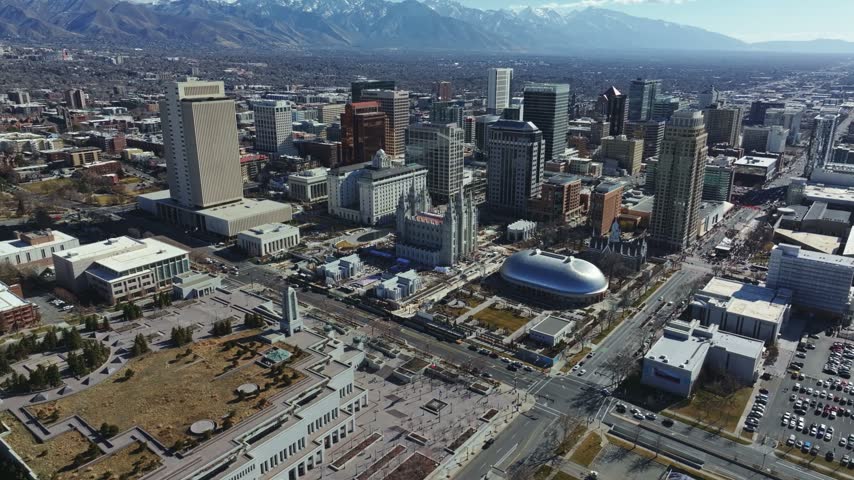 Dolly-in aerial drone wide shot of the famous Salt Lake City Temple under construction, a Latter-day Saints landmark in downtown Salt Lake City, Utah, on a sunny, February day