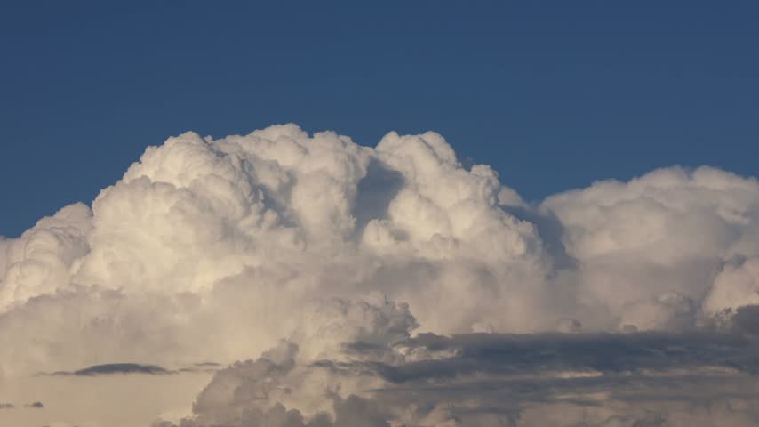  Large white monsoon clouds develop and drift across a deep blue sky over Himachal Pradesh, India, during the rainy season.