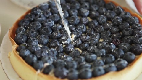 Cutting a blueberry pie into pieces 库存视频