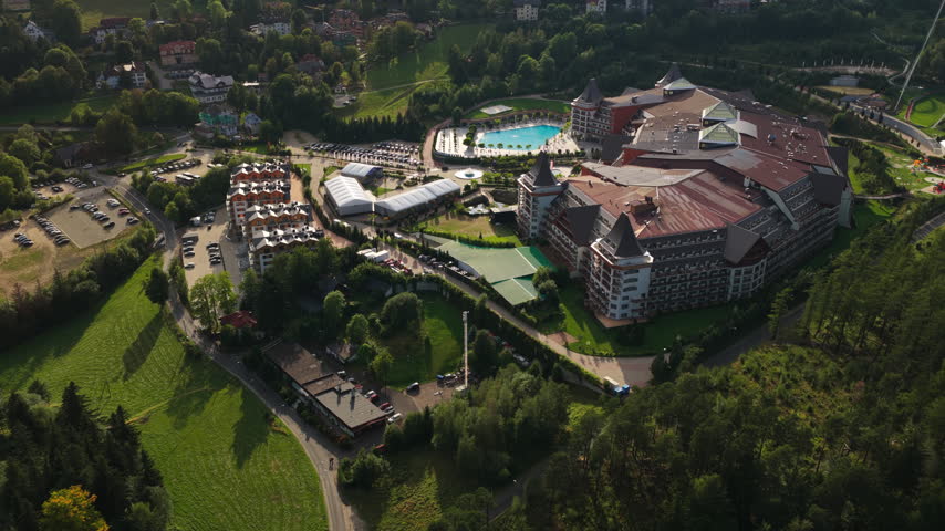 Hotel Golebiewski Resort Complex With Outdoor Pools Nestled In Mountain Valley Forest Landscape In Poland. - aerial shot