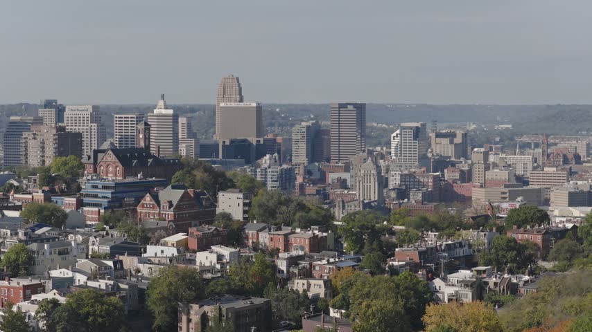 Drone aerial landscape of Cincinnati Ohio downtown center city skyline from above with many buildings, houses, apartments, churches, tall skyscrapers, and businesses near Mount Adams neighborhood hill