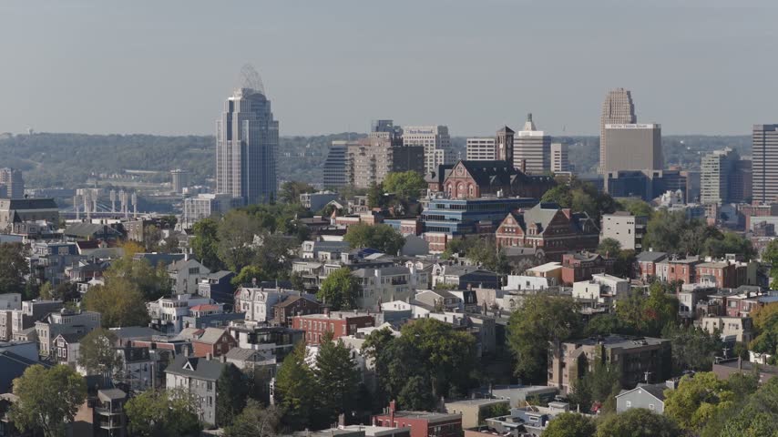 Drone aerial landscape of Cincinnati Ohio downtown center city skyline from above with many buildings, houses, apartments, churches, tall skyscrapers, and businesses near Mount Adams neighborhood hill