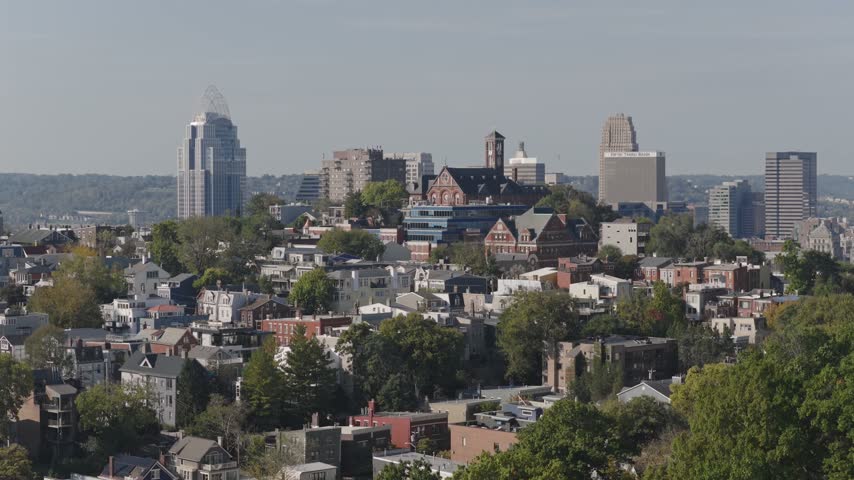 Drone aerial landscape of Cincinnati Ohio downtown center city skyline from above with many buildings, houses, apartments, churches, tall skyscrapers, and businesses near Mount Adams neighborhood hill