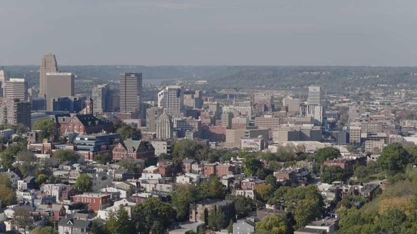 Drone aerial landscape of Cincinnati Ohio downtown center city skyline from above with many buildings, houses, apartments, churches, tall skyscrapers, and businesses near Mount Adams neighborhood hill
