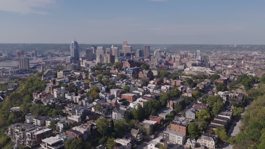 Drone aerial landscape of Cincinnati Ohio downtown center city skyline from above with many buildings, houses, apartments, churches, tall skyscrapers, and businesses near Mount Adams neighborhood hill