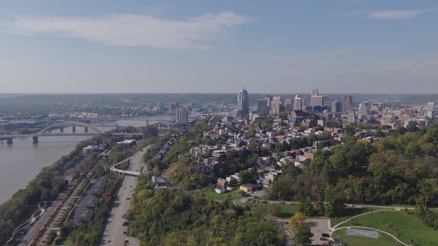 Drone aerial landscape of Cincinnati Ohio downtown center city skyline from above with many buildings, houses, apartments, churches, tall skyscrapers, and businesses near Mount Adams neighborhood hill