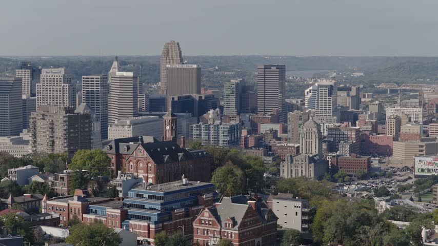 Drone aerial landscape of Cincinnati Ohio downtown center city skyline from above with many buildings, houses, apartments, churches, tall skyscrapers, and businesses near Mount Adams neighborhood hill