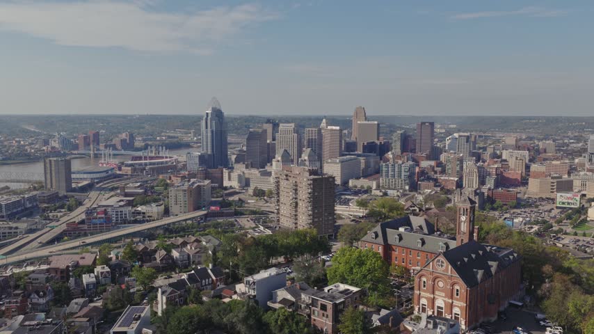 Drone aerial landscape of Cincinnati Ohio downtown center city skyline from above with many buildings, houses, apartments, churches, tall skyscrapers, and businesses near Mount Adams neighborhood hill