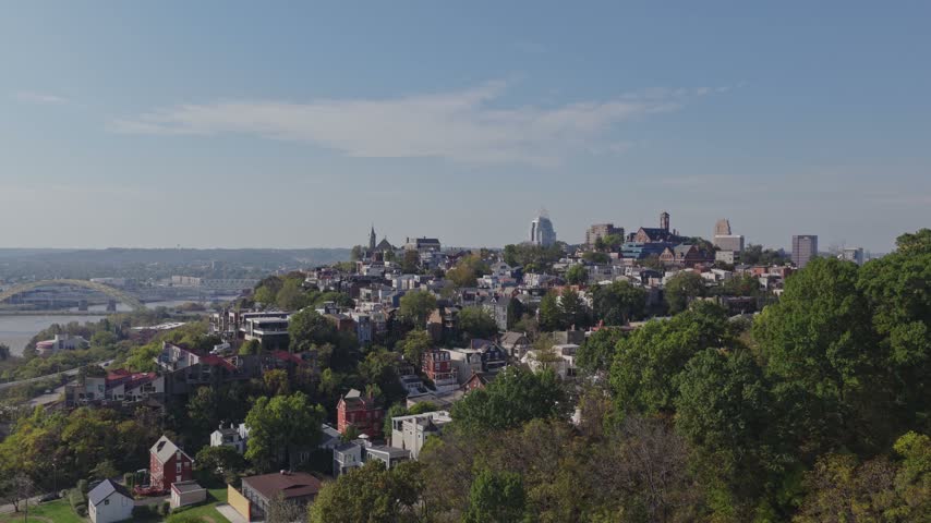 Drone aerial landscape of Cincinnati Ohio downtown center city skyline from above with many buildings, houses, apartments, churches, tall skyscrapers, and businesses near Mount Adams neighborhood hill