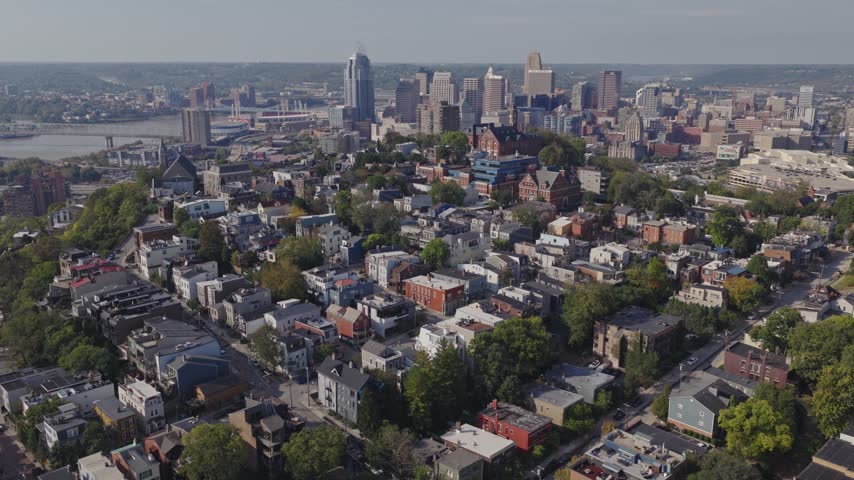 Drone aerial landscape of Cincinnati Ohio downtown center city skyline from above with many buildings, houses, apartments, churches, tall skyscrapers, and businesses near Mount Adams neighborhood hill