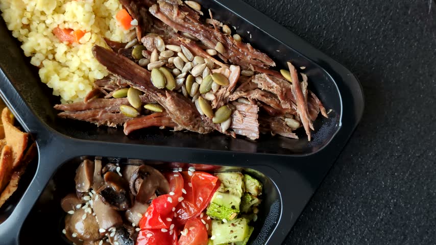 A bowl with beef, porridge, mushrooms, vegetables, sauce, and spices. Beef bowl