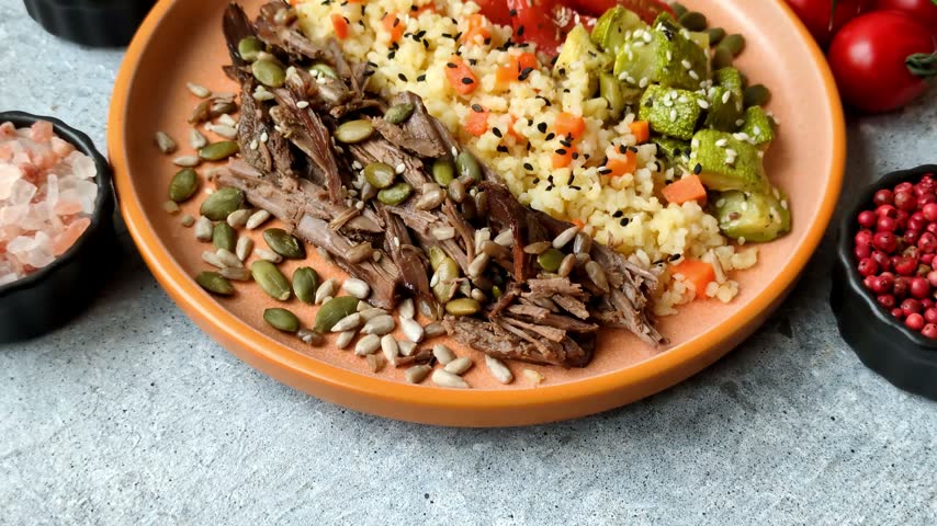 A bowl with beef, porridge, mushrooms, vegetables, sauce, and spices. Beef bowl