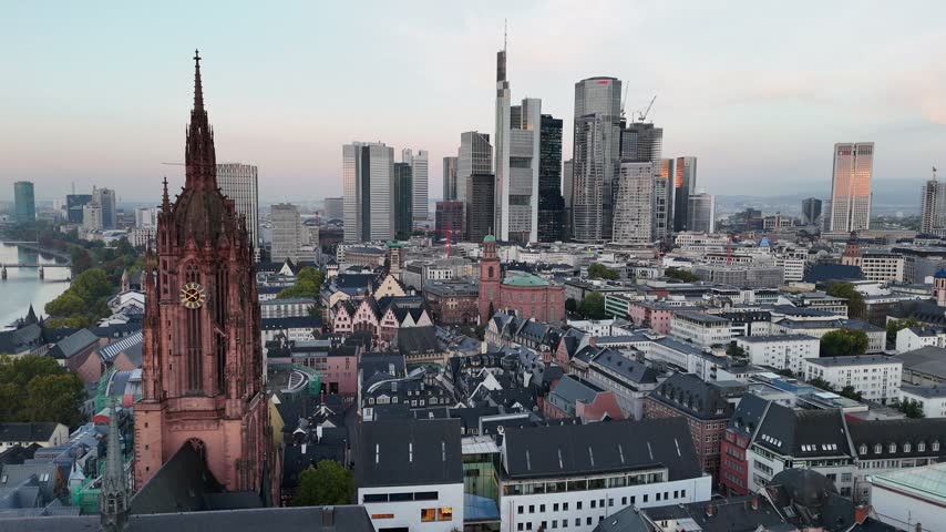 Aerial view of the historic Frankfurt Cathedral standing prominently before the modern glass skyscrapers of the financial district in Frankfurt am Main, Hessen, Germany.