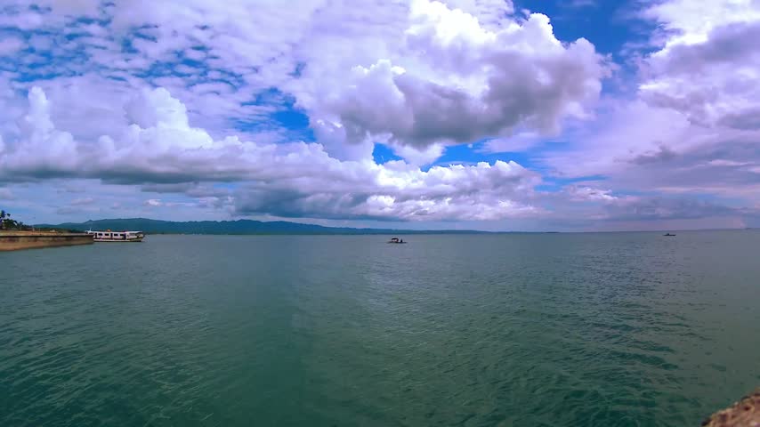 Sea, horizon, island, mountain, embankment. Clouds.