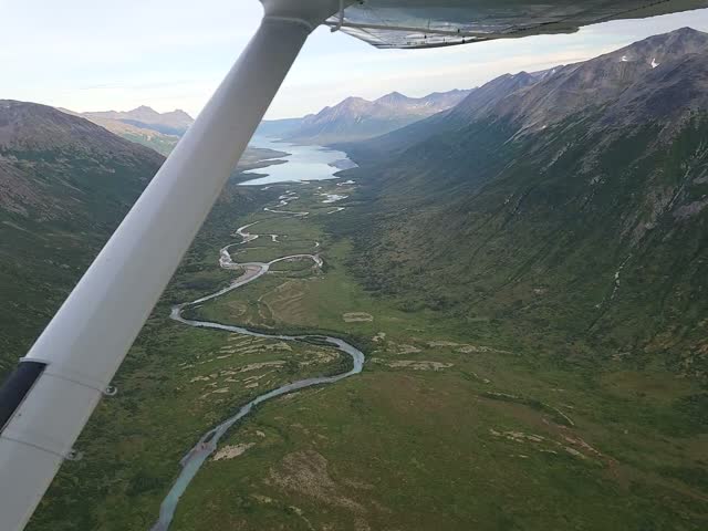 Aerial view from a floatplane over a braided river valley and green tundra over Katmai National Park, Alaska