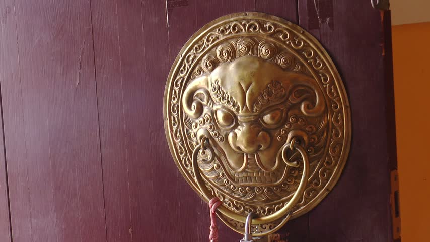Relief images of a guardian lion with a ring in its mouth on the doors of a Buddhist temple. Mongolia, Khamar-hit monastery in the Gobi Desert.