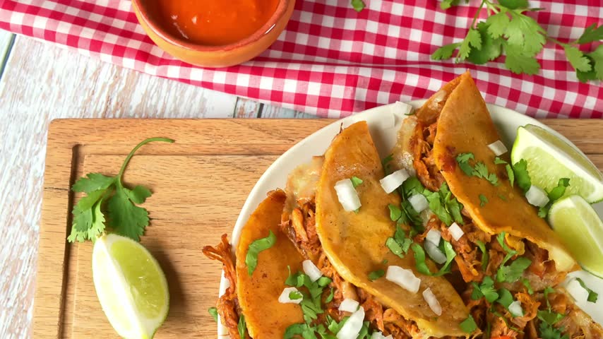 Authentic Mexican birria tacos with red salsa and lime