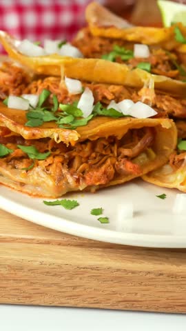 Traditional Mexican quesabirria tacos with shredded beef, melted cheese, cilantro and diced onions on corn tortillas