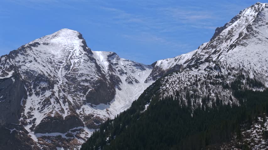 Breathtaking aerial footage of the majestic High Tatras mountains in Slovakia. Snow capped peaks against a clear blue sky in early spring
