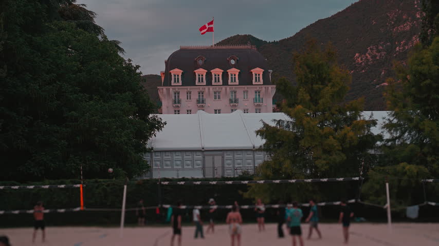 People Playing Beach Volleyball at Dusk in Front of Imperial Palace in Annecy, France