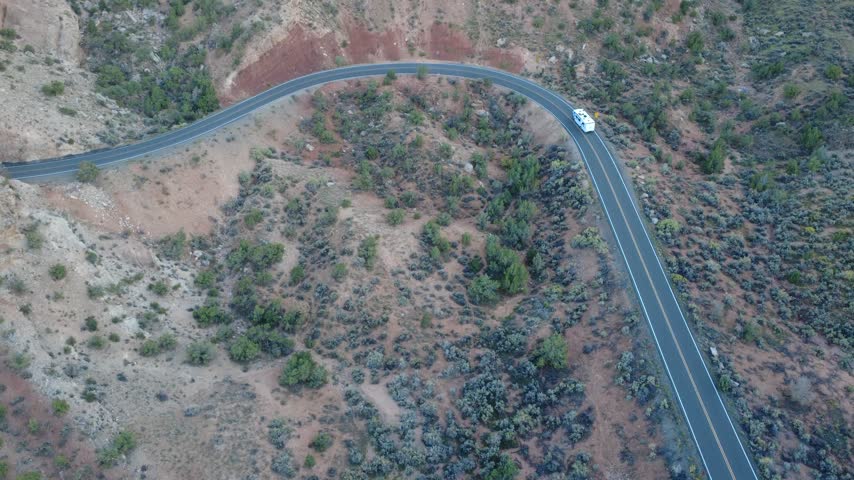 Top down aerial view of hairpin bend on winding mountain road.