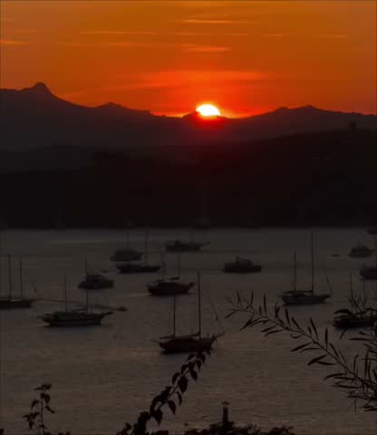 a sunset over a coastal bay with moored boats and hills in the background, in Bodrum in Turkey. 
08.08.2025