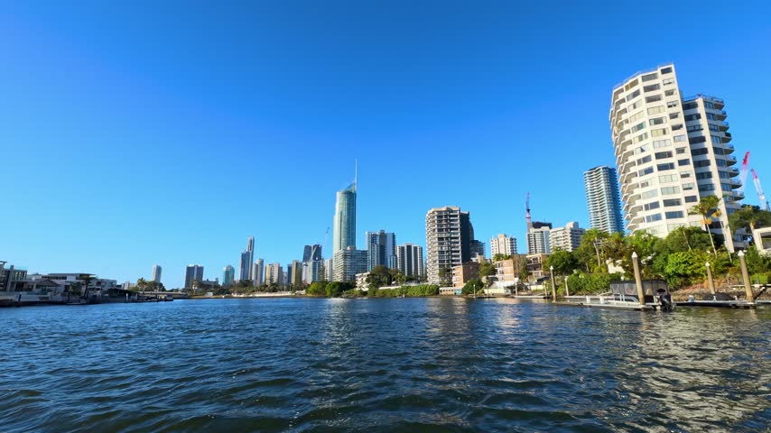 Cruising along the river towards modern skyscrapers and waterfront properties in Gold Coast, Australia.