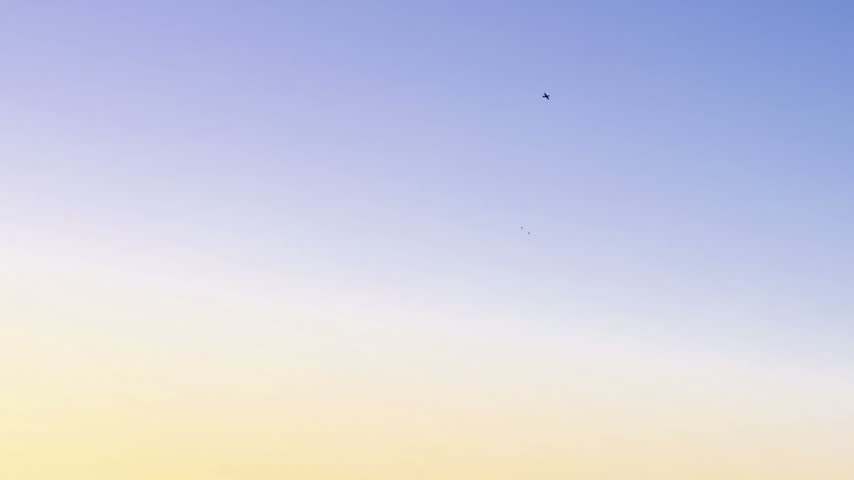 Two P-51 Mustangs approach and turn together above Sacramento at dusk.