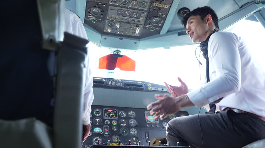 trained airplane captain in uniform preparing to fly in a simulator cockpit.