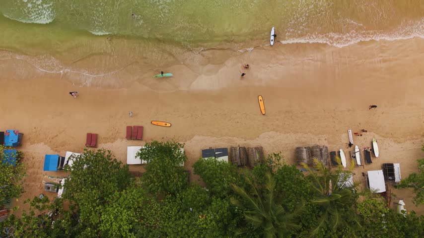 Weligama beach surf schools teaching tourists on the sand top-down static view in sri lanka.